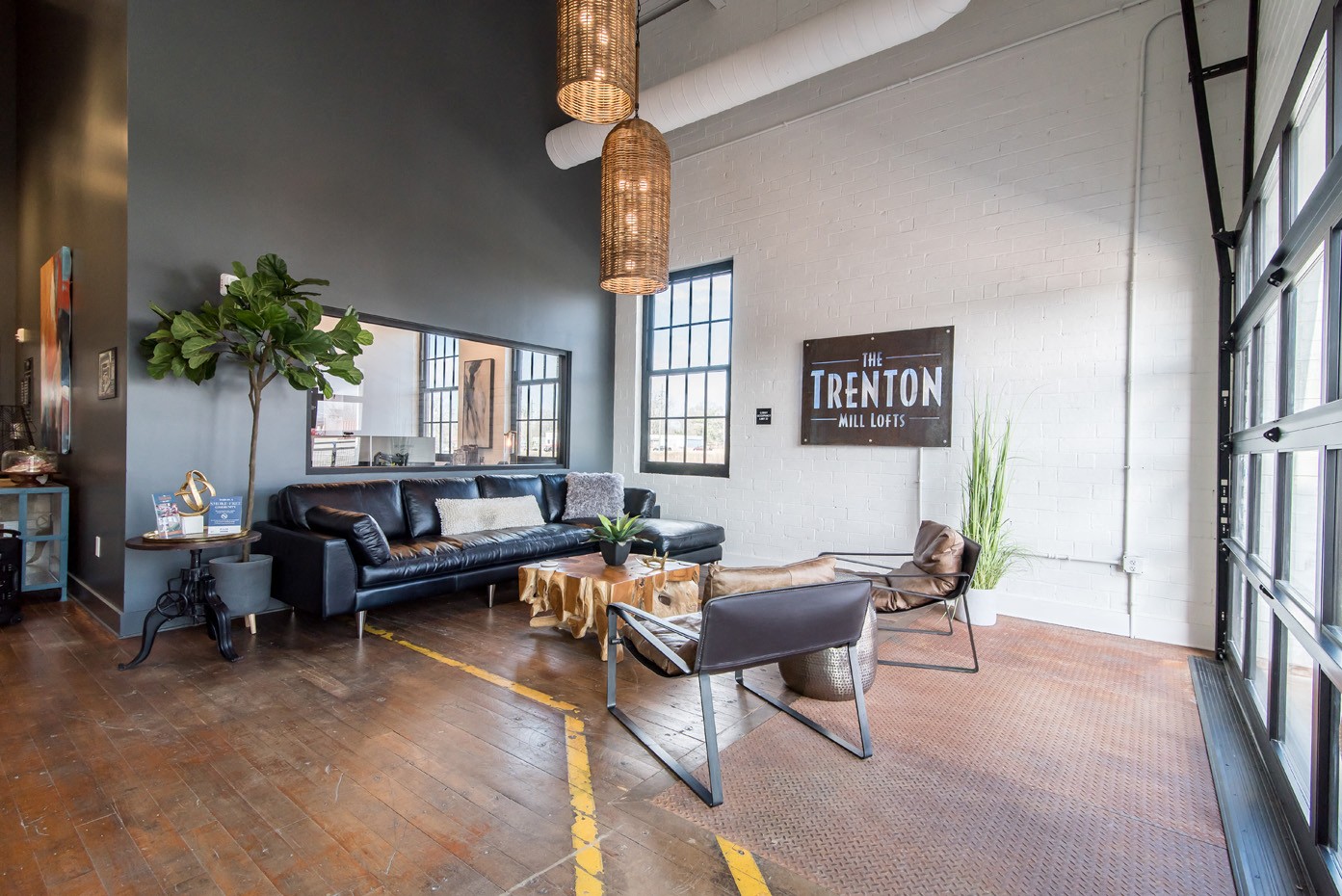 a living room with leather couches and chairs and a large window