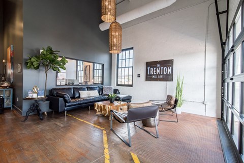 a living room with leather couches and chairs and a large window