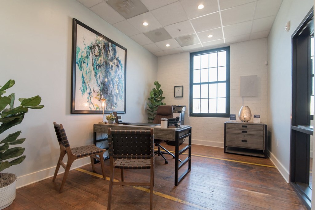 an office with a desk and chairs and a window
