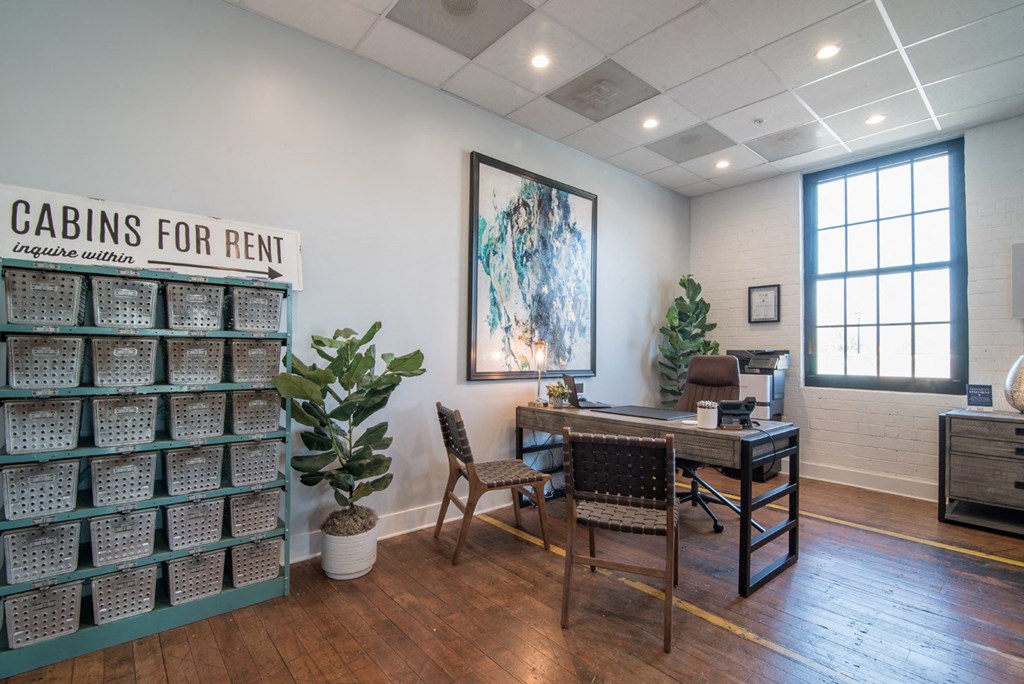 a conference room with a desk and chairs and a wall with aueduedued