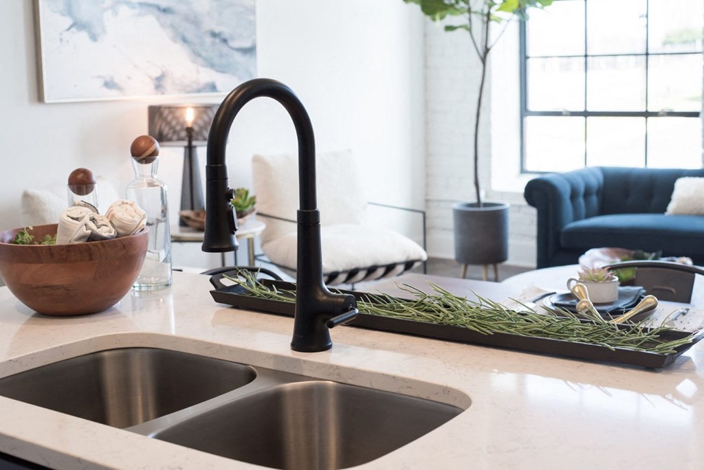 a kitchen sink with a black faucet in a living room