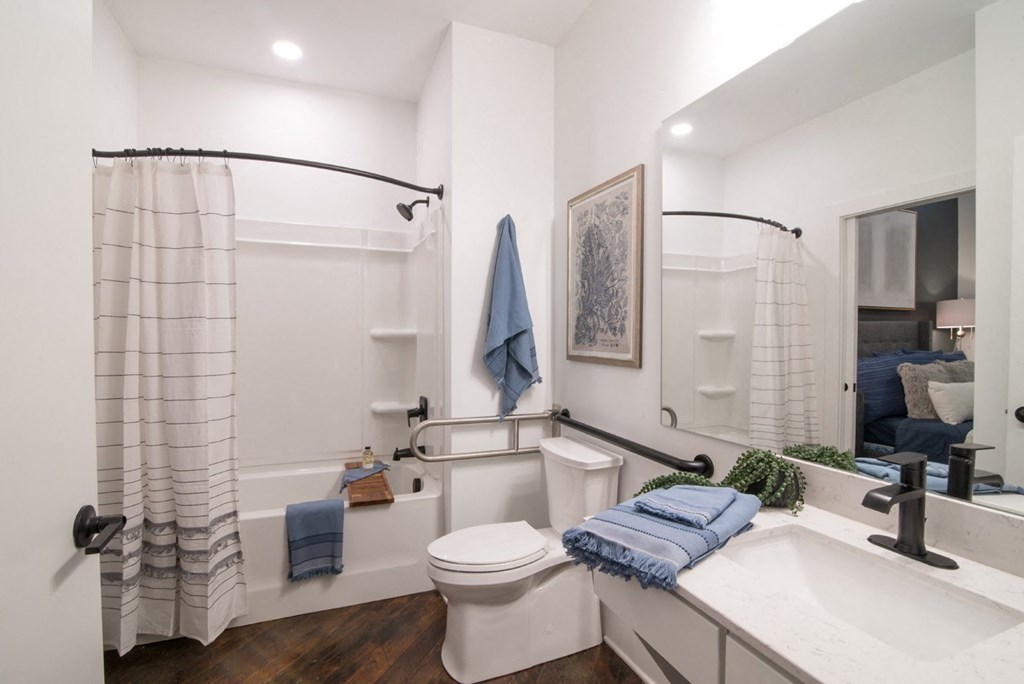 a bathroom with a toilet sink and tub and a mirror