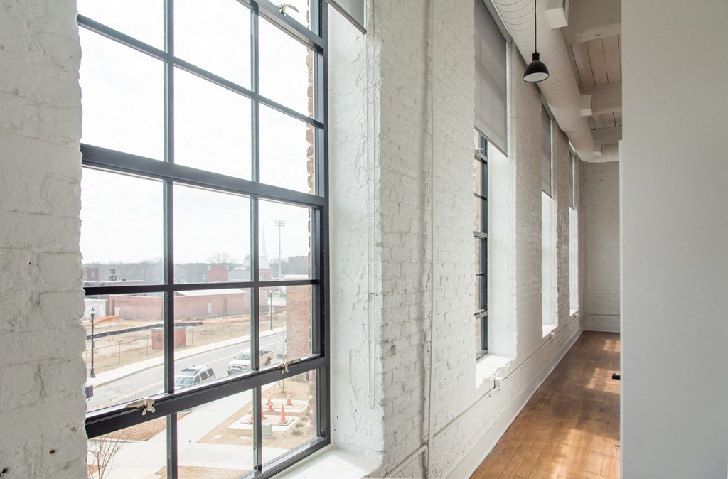 a corridor with large windows and a view of a city