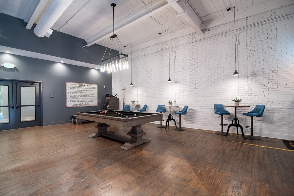 a game room with a pool table and a white brick wall