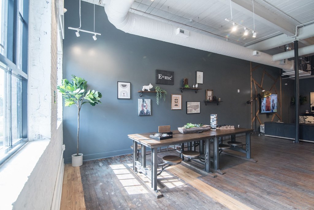 a dining room with a table and chairs in front of a blue wall
