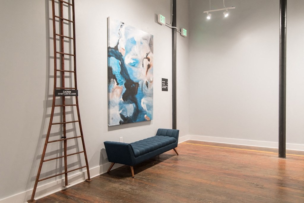 a painting in a room with a chair and a ladder