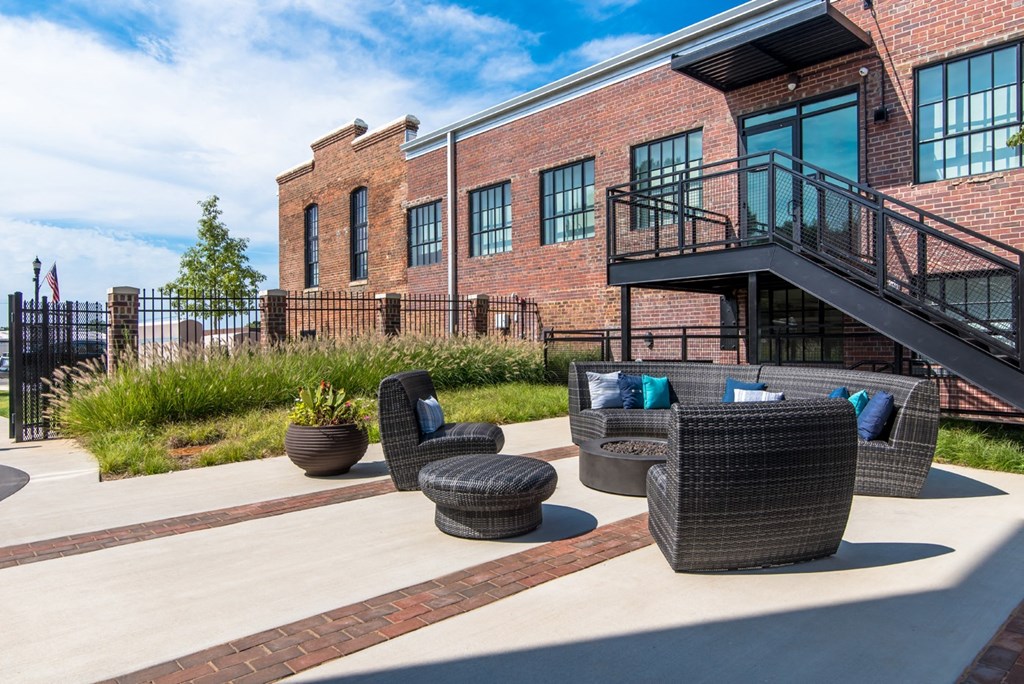 a patio with chairs and a building in the background
