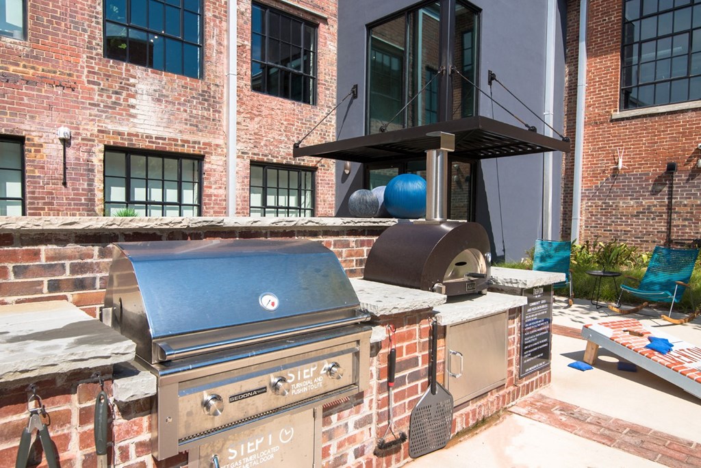 a backyard with a barbecue grill and a brick wall