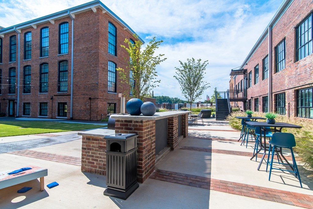 a patio with tables and chairs outside of a brick building