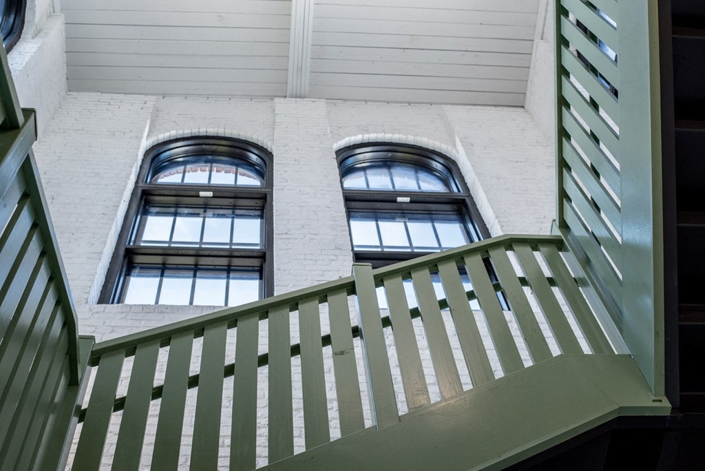 two windows on the side of a building with a balcony