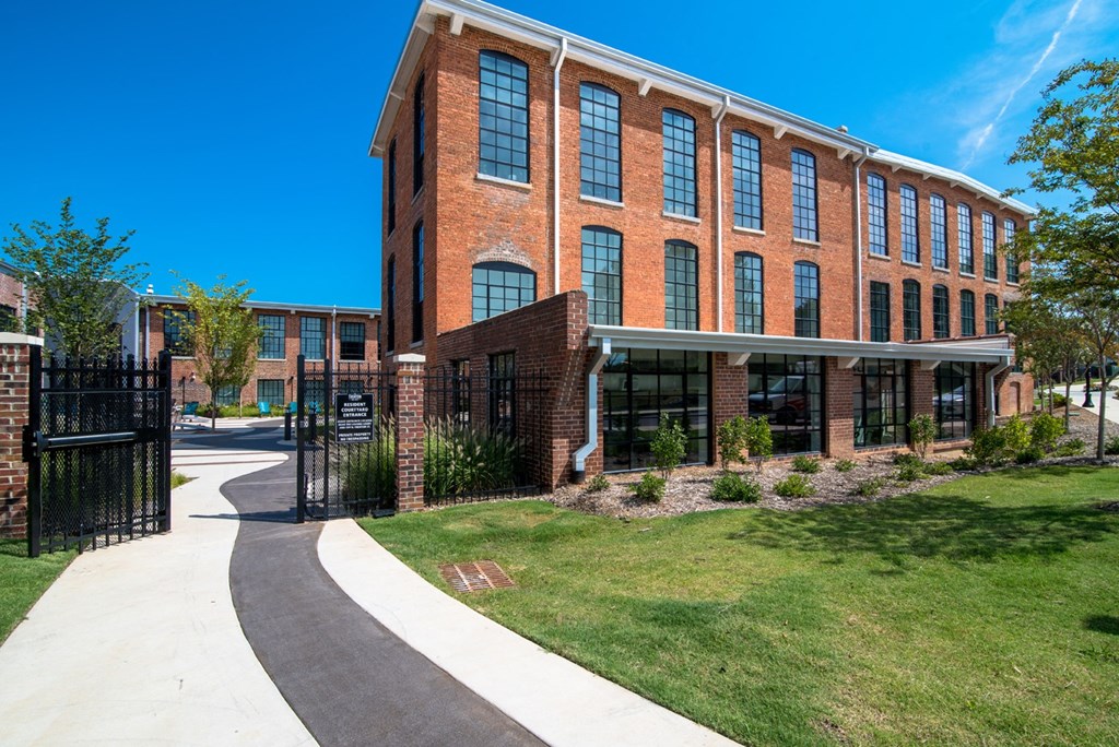 a large brick building with a sidewalk in front of it