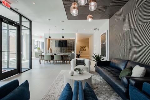 Elegant lobby area with bold accent wall, artistic lighting, and comfortable seating—modern design meets comfort at The Rail Bound Brook.