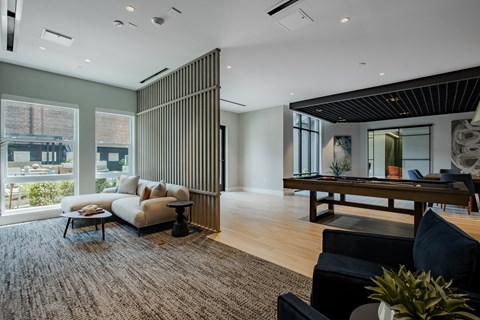 Modern resident lounge at The Rail at Bound Brook featuring natural light, plush seating, and views of the outdoor courtyard.