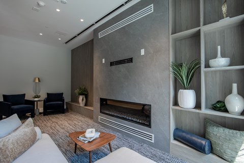 Cozy lounge nook with modern fireplace and built-in shelving inside The Rail at Bound Brook’s game room.