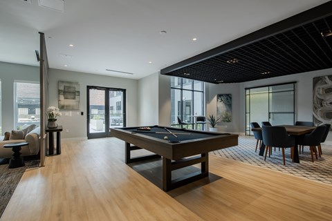 Spacious game room at The Rail at Bound Brook showcasing contemporary design, billiards table, and direct courtyard access.