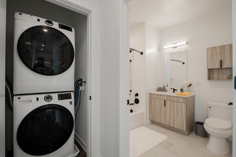 Modern apartment bathroom and in-unit laundry at The Rail in Bound Brook, NJ—complete with stackable washer/dryer, luxury finishes, and resident perks for comfortable living.