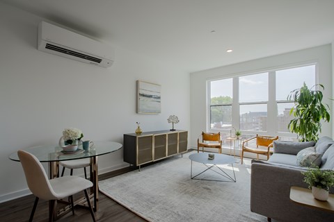 Bright living room at The Rail at Bound Brook featuring oversized windows, modern decor, and natural light—luxury apartment living in NJ.