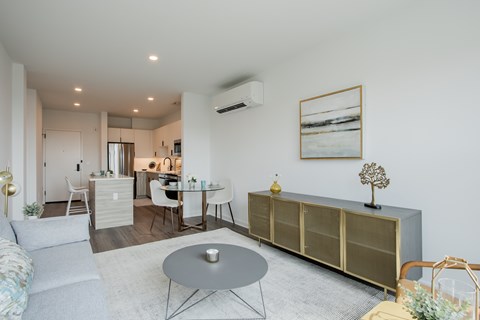 Contemporary kitchen at The Rail featuring white cabinetry, subway tile backsplash, stainless steel appliances, and natural light from large windows.