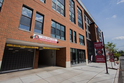 Street-level image of The Rail at Bound Brook luxury apartments with visible garage entrance.