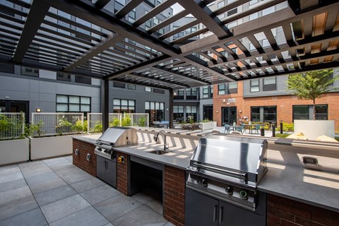 Built-in stainless steel grills and outdoor kitchen at The Rail at Bound Brook’s resident courtyard—premium apartment amenities in Bound Brook, NJ.