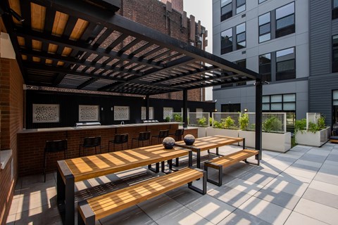Outdoor bar and shaded picnic tables at The Rail at Bound Brook—designed for luxury apartment residents in Bound Brook, NJ.