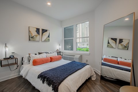 Spacious bedroom in a modern Bound Brook apartment featuring large windows at The Rail at Bound Brook, NJ.