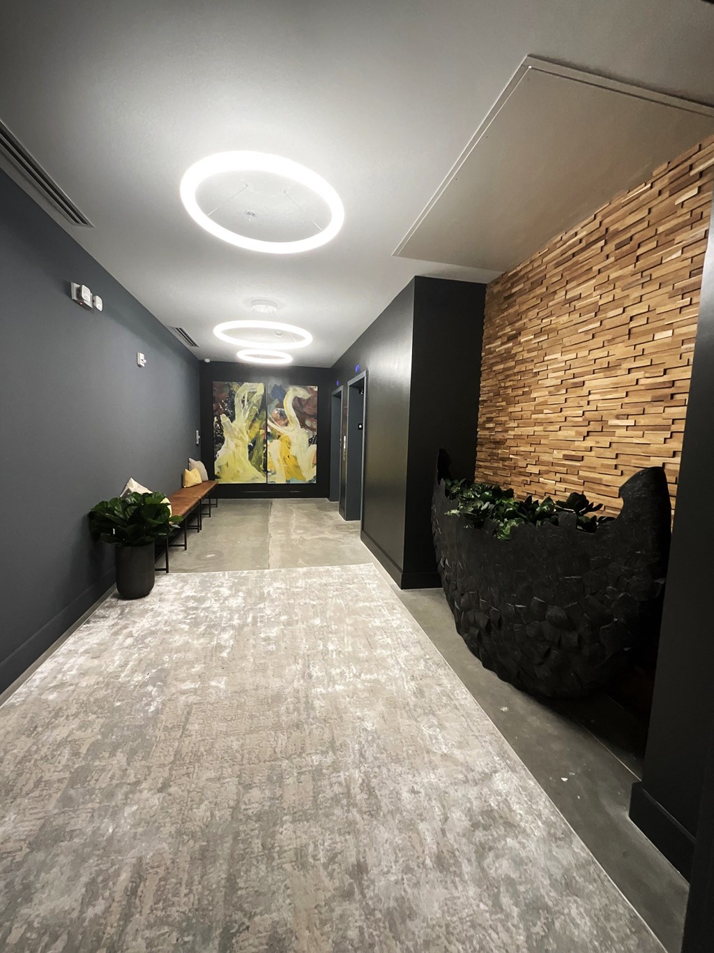 a long hallway with a brick wall and a carpeted floor and a long bench