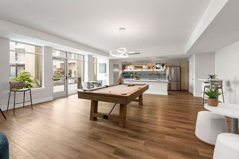 A stylish resident game lounge featuring a pool table, entertainment space, and modern gathering areas at NOVI Concord in Downtown Concord, NC.