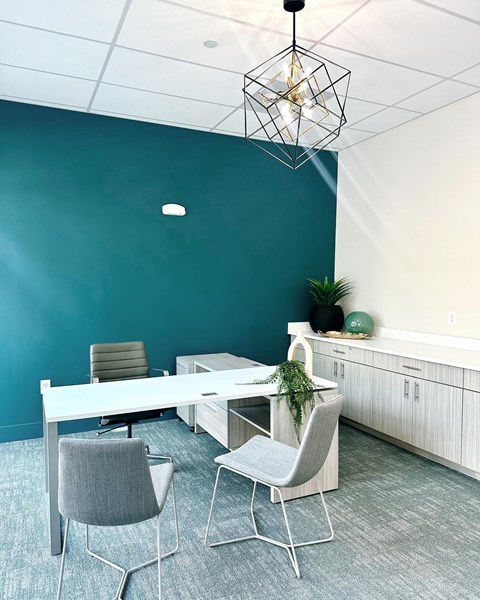 a conference room with a blue wall and a white table and chairs