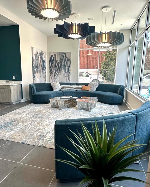 A living room with a blue couch and a rug.