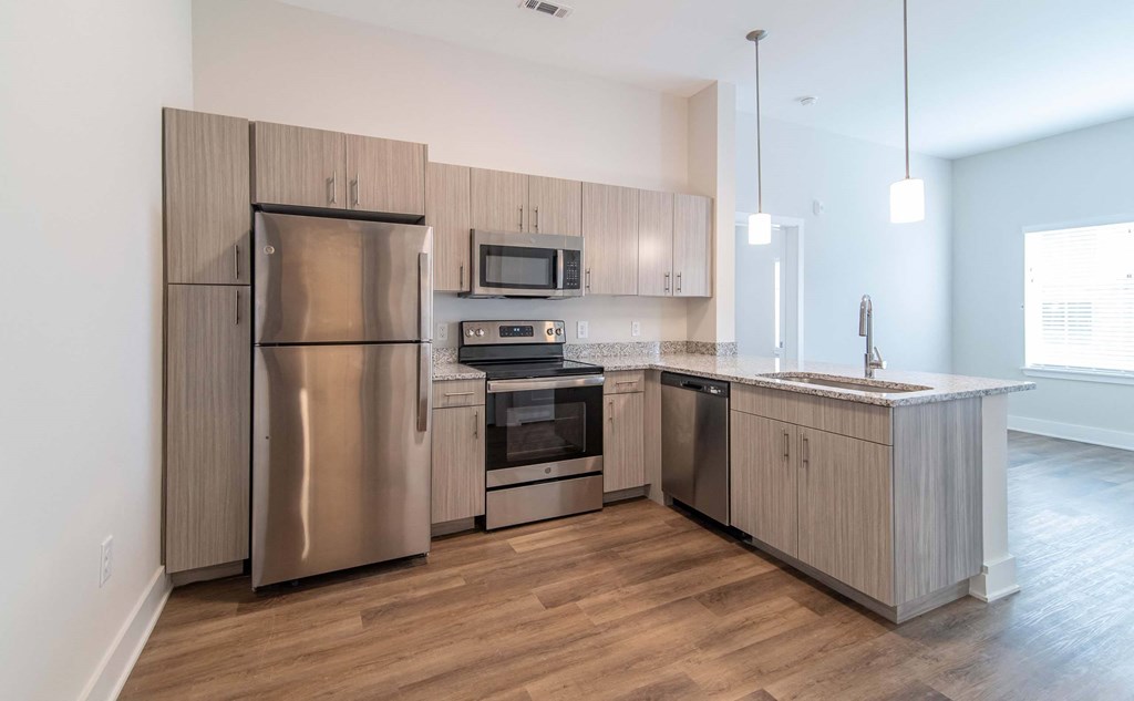 A modern kitchen with stainless steel appliances and granite countertops at NOVI Rise in Concord, NC