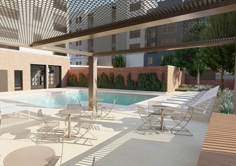 A pool area with chairs and a table under a shaded roof.
