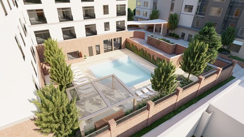 A pool surrounded by trees and a building in the background.