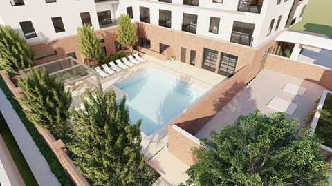 A swimming pool is surrounded by trees and a building.