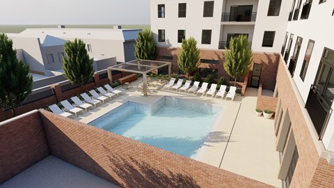 A pool surrounded by a brick wall and lounge chairs.