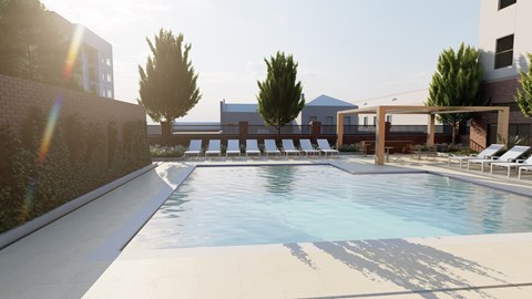 A large outdoor swimming pool with sun loungers and trees.