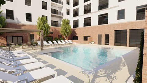 A pool surrounded by sun loungers and trees.