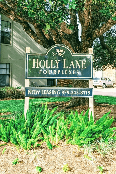 A sign for Holly Lane Fourplexes with a phone number for leasing.