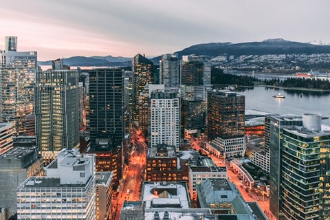 A cityscape with buildings and a body of water.