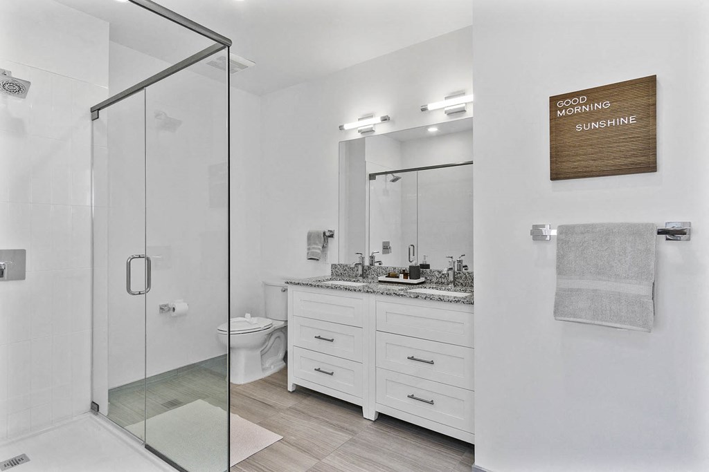 A bathroom with a glass shower door and a mirror above the sink at 10 N. Main Apartments, Wharton, New Jersey