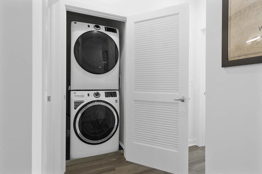 Two washing machines are stacked in a small laundry room at 10 N. Main Apartments, Wharton, NJ, 07885
