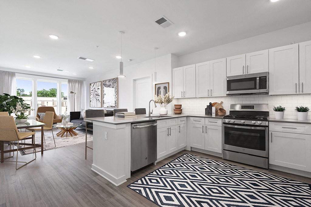 an open kitchen and living room with white cabinets and a black and white rug
