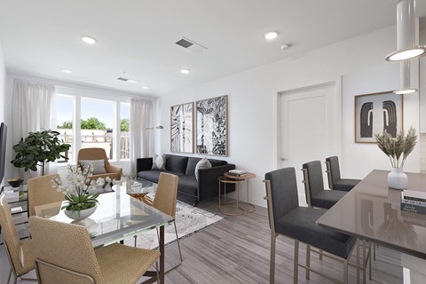 a living room and dining room with a glass table and chairs