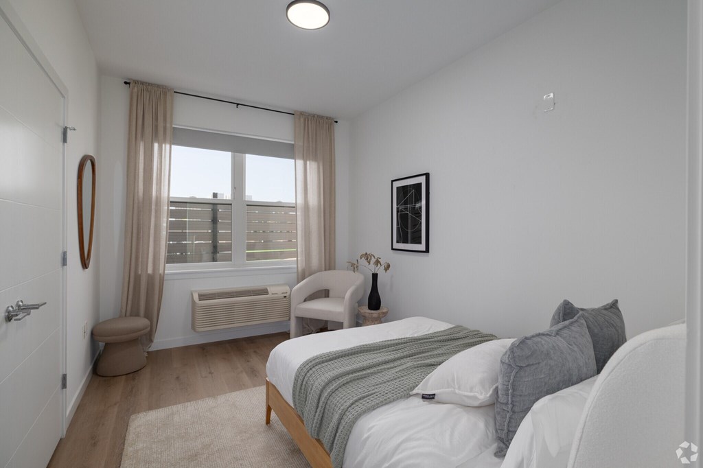 A Bedroom With Grey Pillows at Hue Soul Apartments, East Orange, NJ