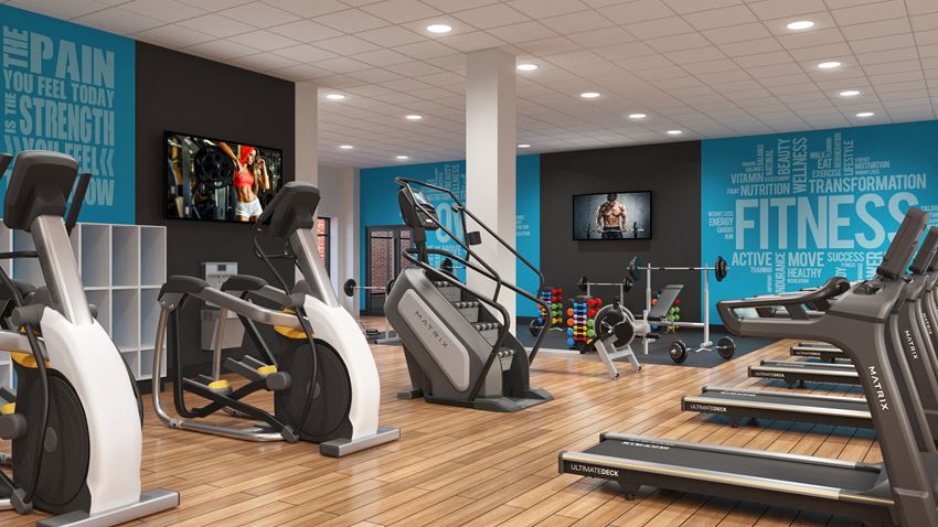 a gym with treadmills and other exercise equipment on a wood floor