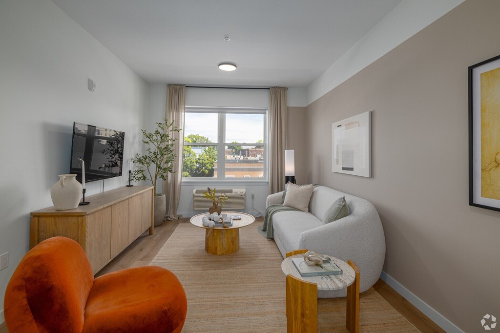 A Living Room With Orange Chair at Hue Soul Apartments, East Orange, NJ, 07018