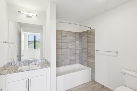 A white bathroom with a tub, sink, and toilet.