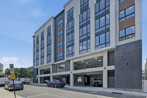 A modern building with a parking lot in front.