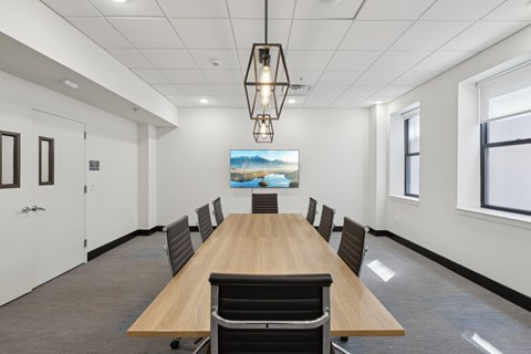 A conference room with a long table and chairs.