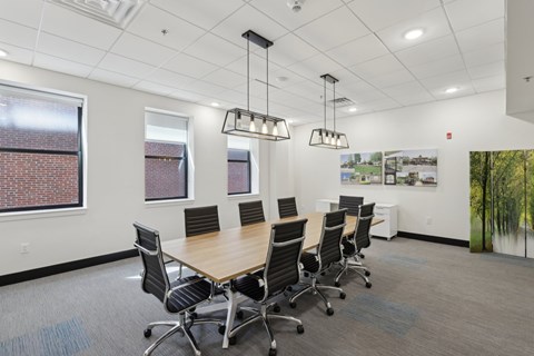 A conference room with a long table and chairs.